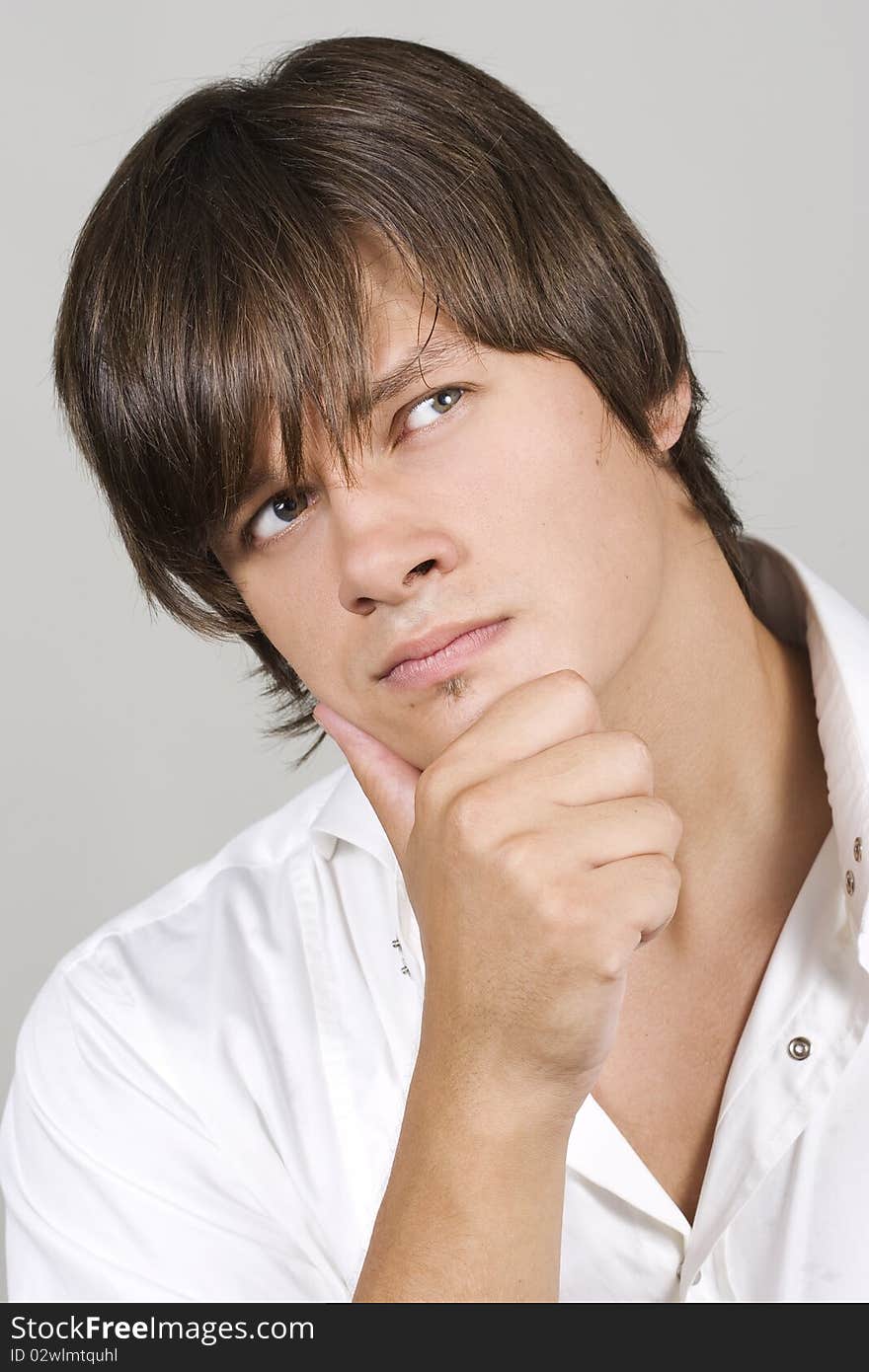 Closeup of a handsome young man thinking