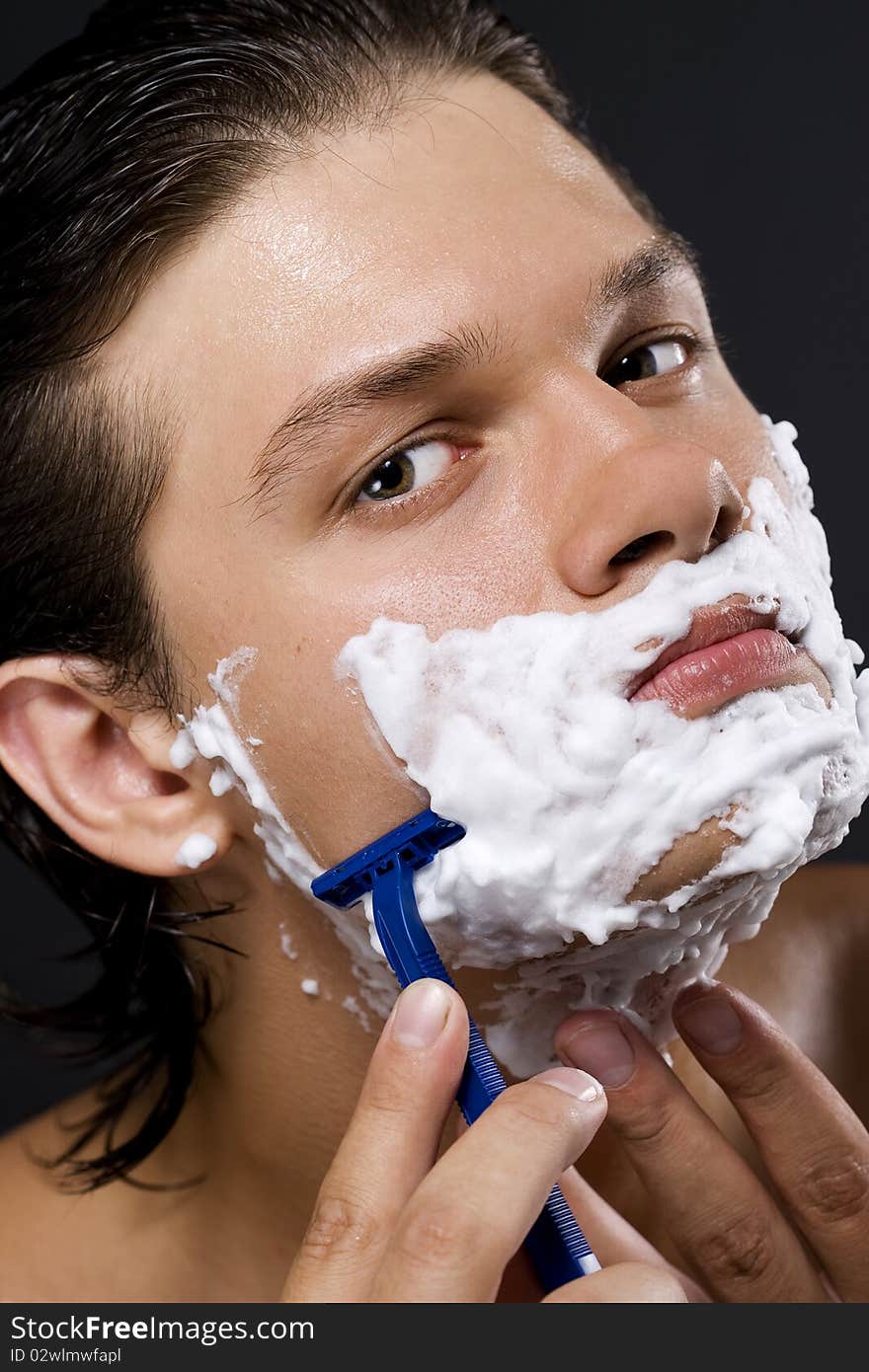 handsome young man shaving. handsome young man shaving