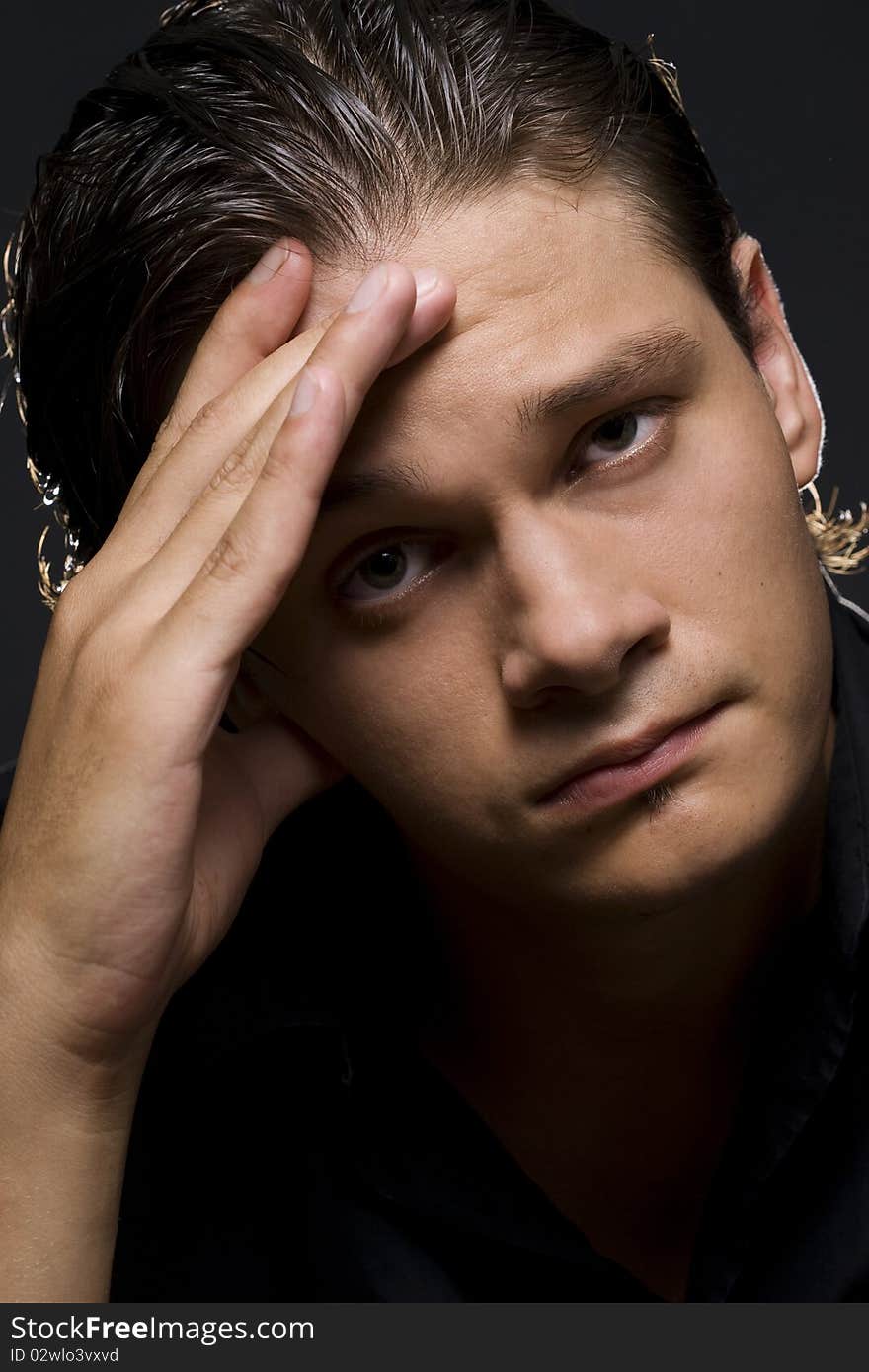 Closeup portrait of a upset young man with hand on his head