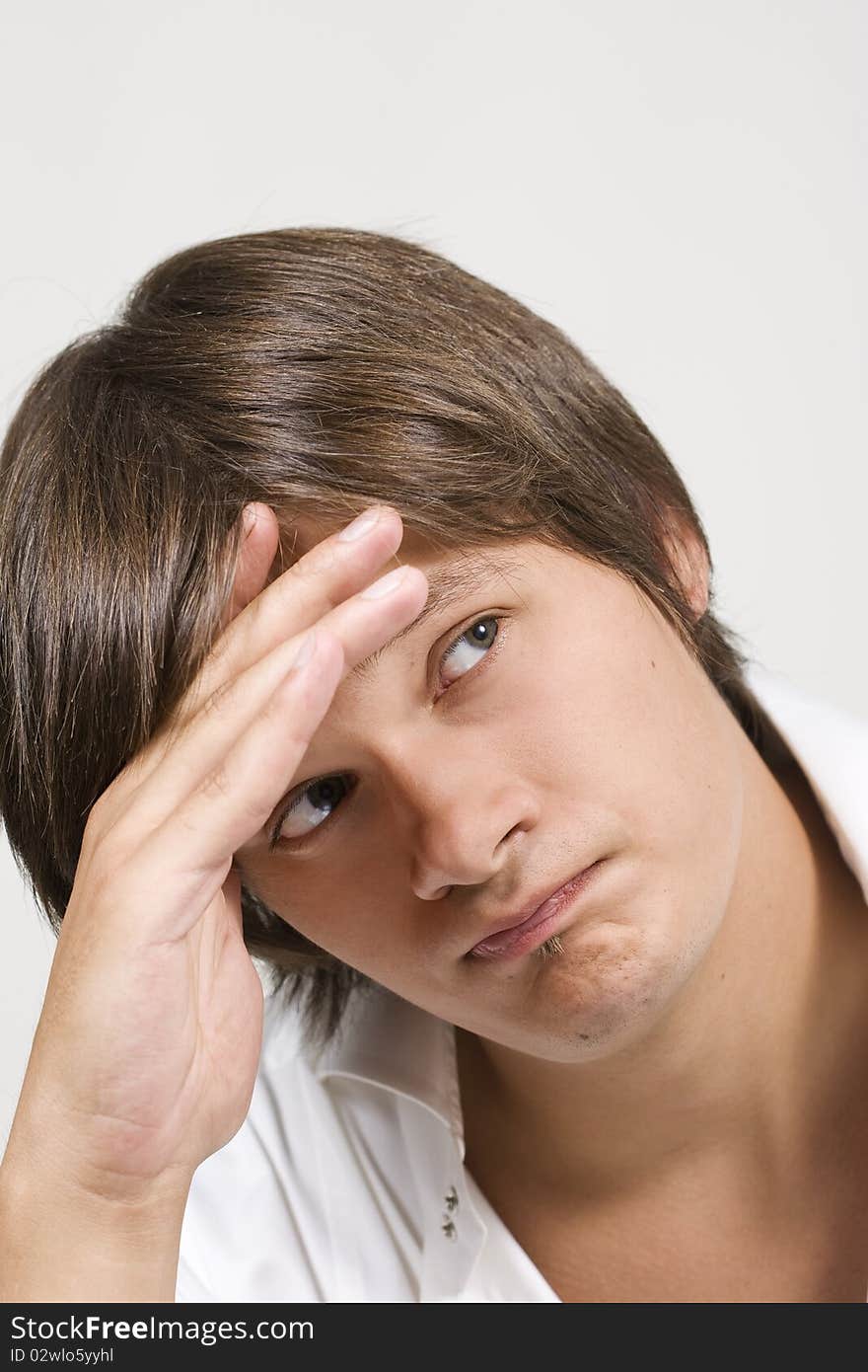 Closeup portrait of a upset young man with hand on his head