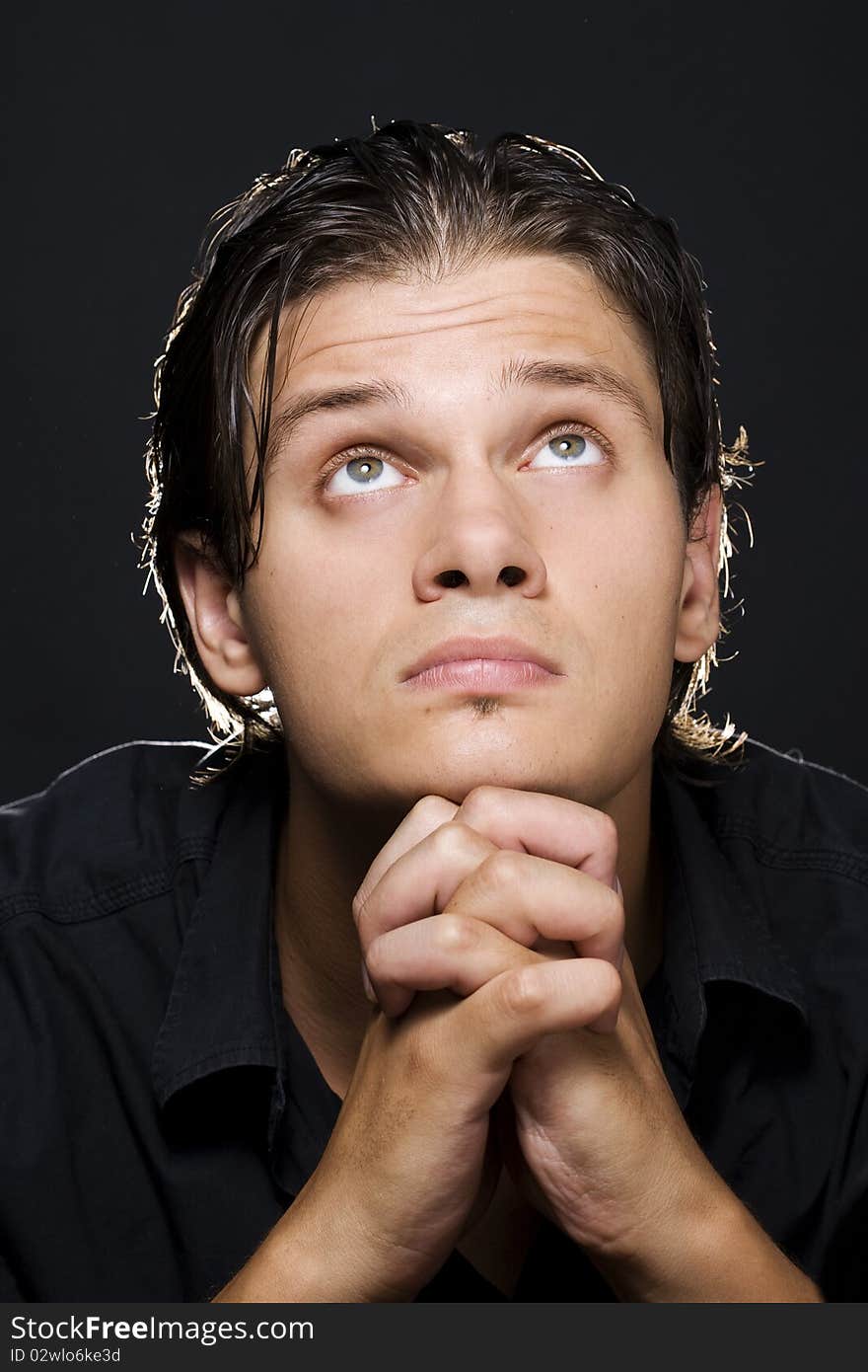 Closeup portrait of a young man praying to god