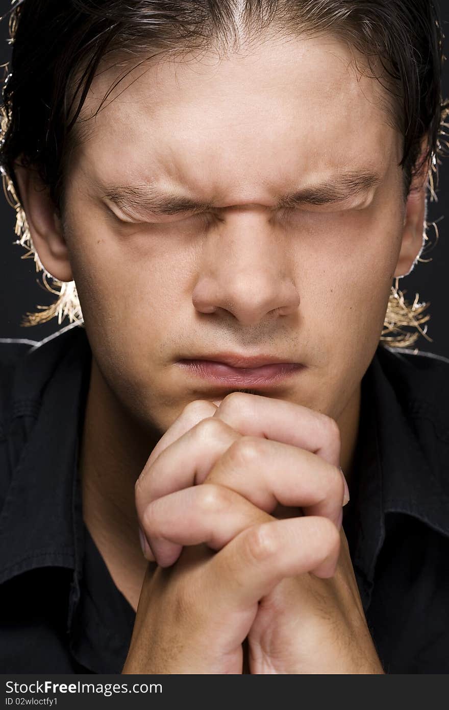 Closeup portrait of a young man praying to god