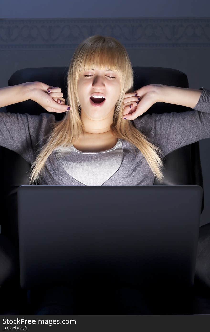 Yawning Woman with Laptop Stretching Her Arms