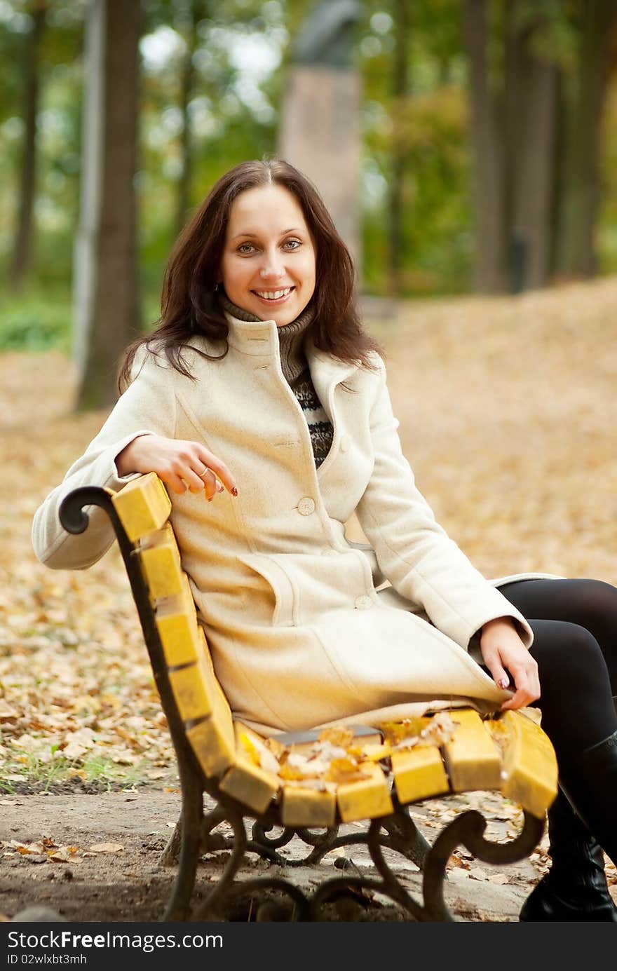 Young woman sitting on bench and smilling