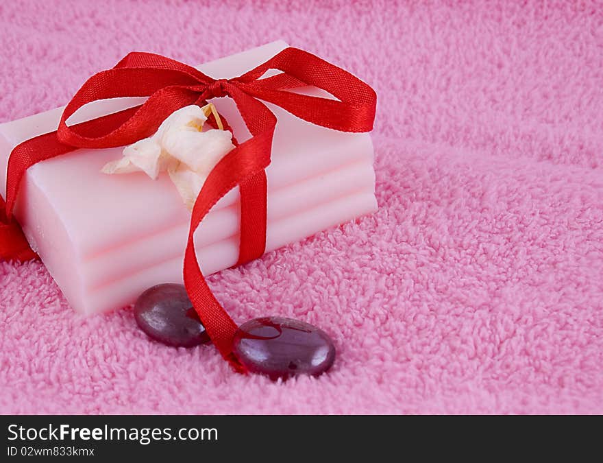 Soap with roses and stones over pink towel