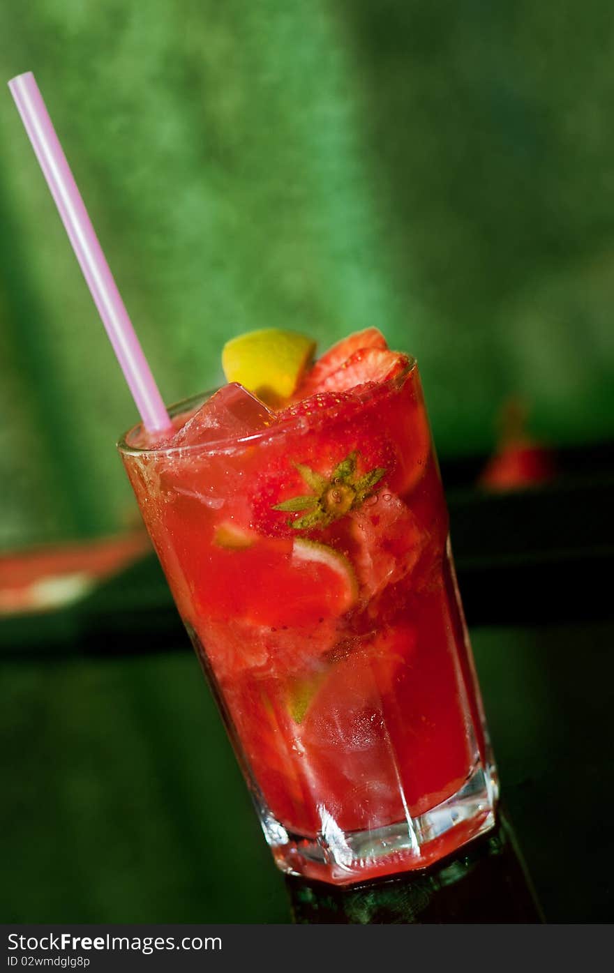 Red Mojito Cocktail with Energy Drink, Strawberries and Lemon isolated on green background. Red Mojito Cocktail with Energy Drink, Strawberries and Lemon isolated on green background