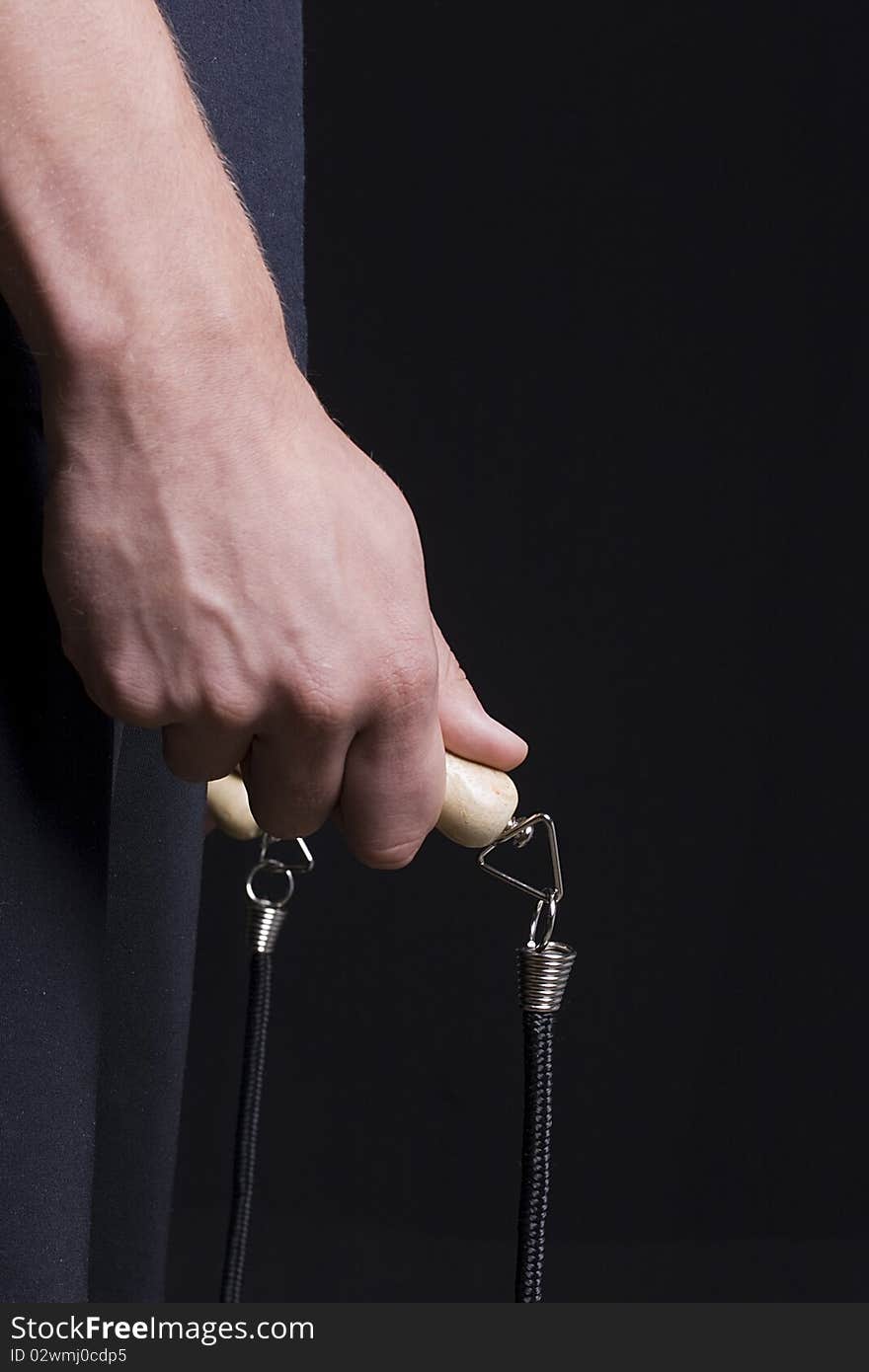 Human hand holding a jump rope on a black background. Human hand holding a jump rope on a black background.