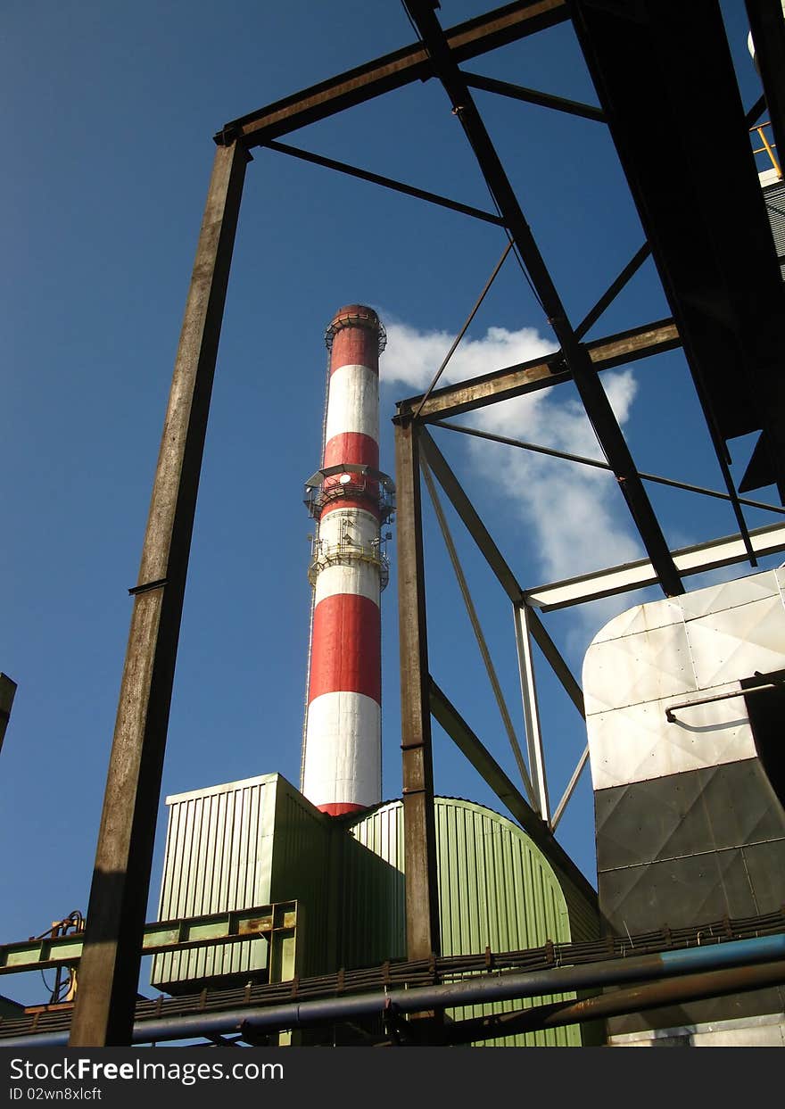 Red and white chimney with outgoing exhaust gases or steam