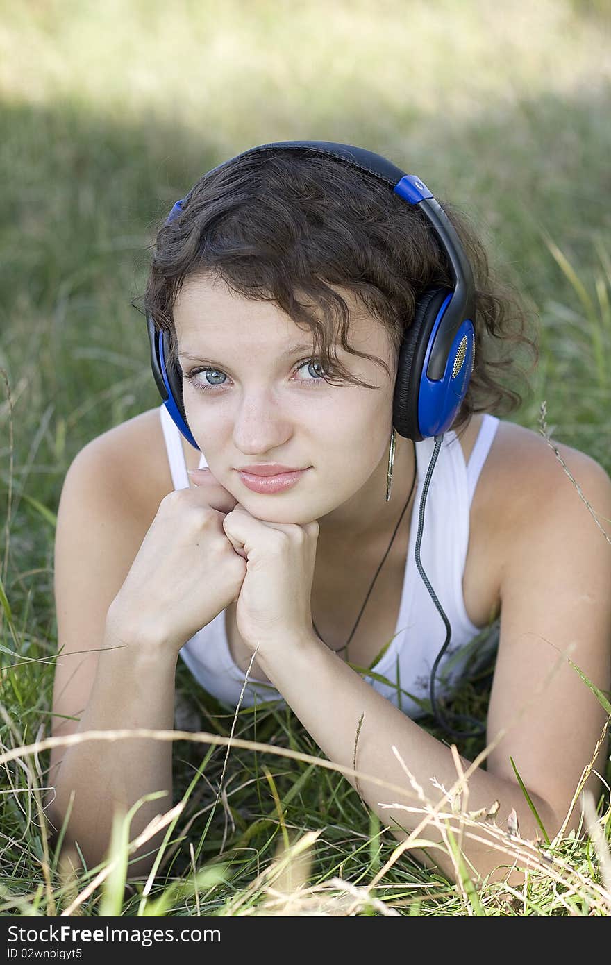 Young Girl Listens To Music On The Nature