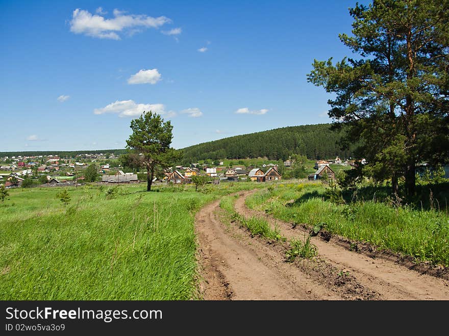 Summer landscape with a country road going to the Russian village. Summer landscape with a country road going to the Russian village