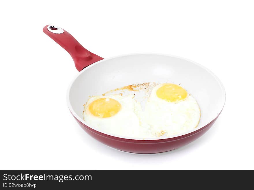 Broken Egg Frying In A Pan Isolated On White