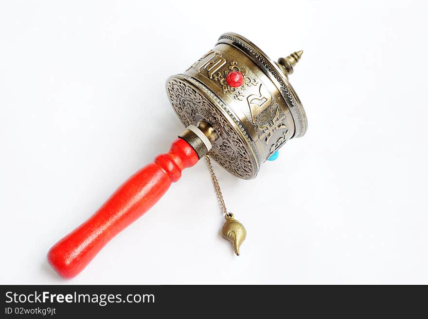 A Tibetan prayer wheel isolated on a white background.