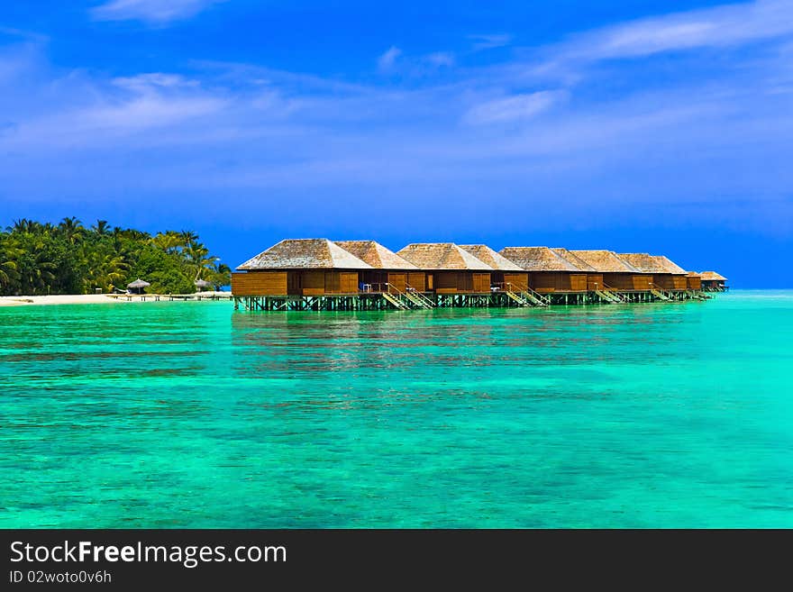 Water bungalows on a tropical island - travel background