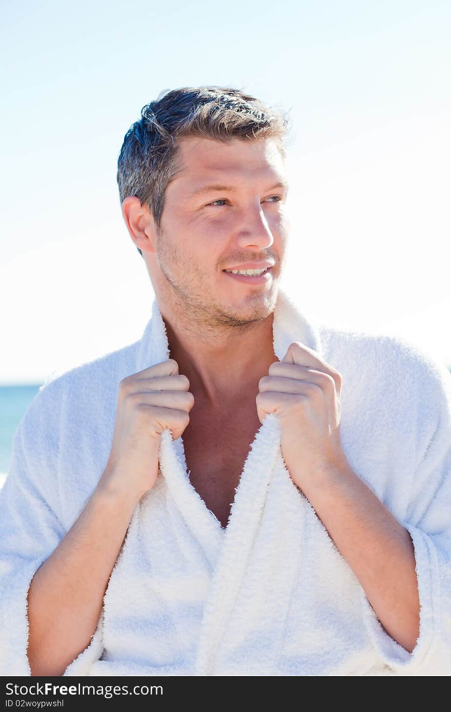 Sexy beauty male on the blue beach wearing a bathrobe. Sexy beauty male on the blue beach wearing a bathrobe