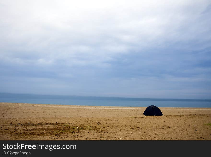 A beach scene with accumulated clouds and a tent. A beach scene with accumulated clouds and a tent