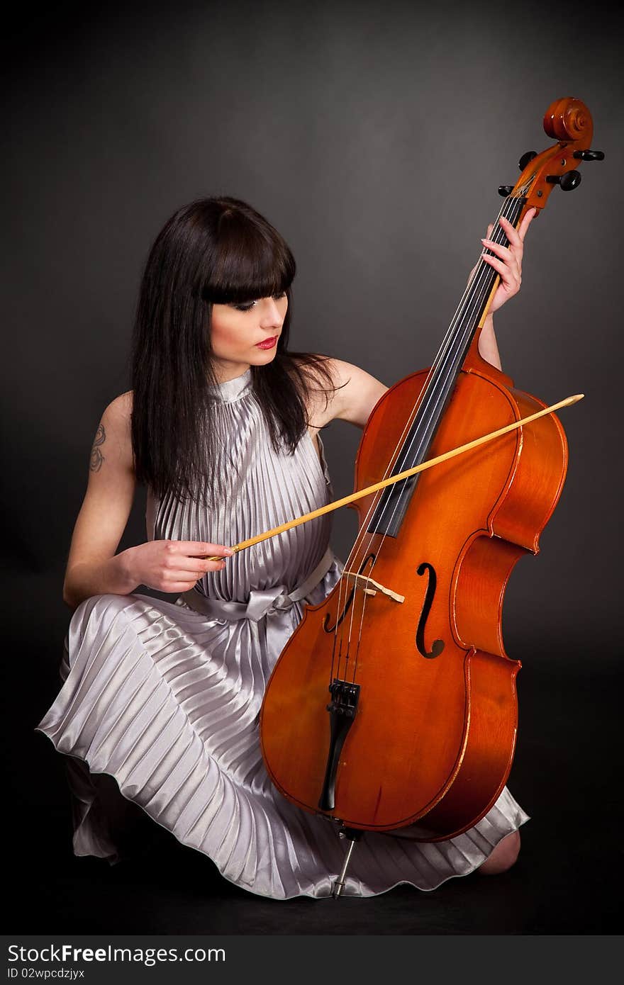 Girl with cello, studio isolated shot