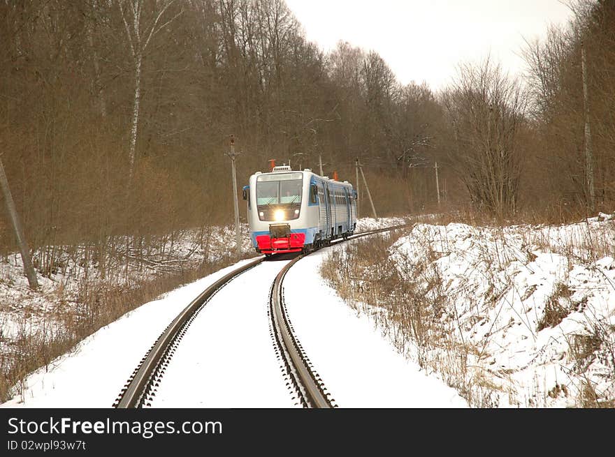 Railcar traveling by rail through the forest in winter. Railcar traveling by rail through the forest in winter