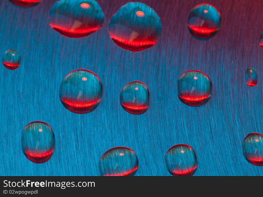 Color drops of water on textured metal. Color drops of water on textured metal