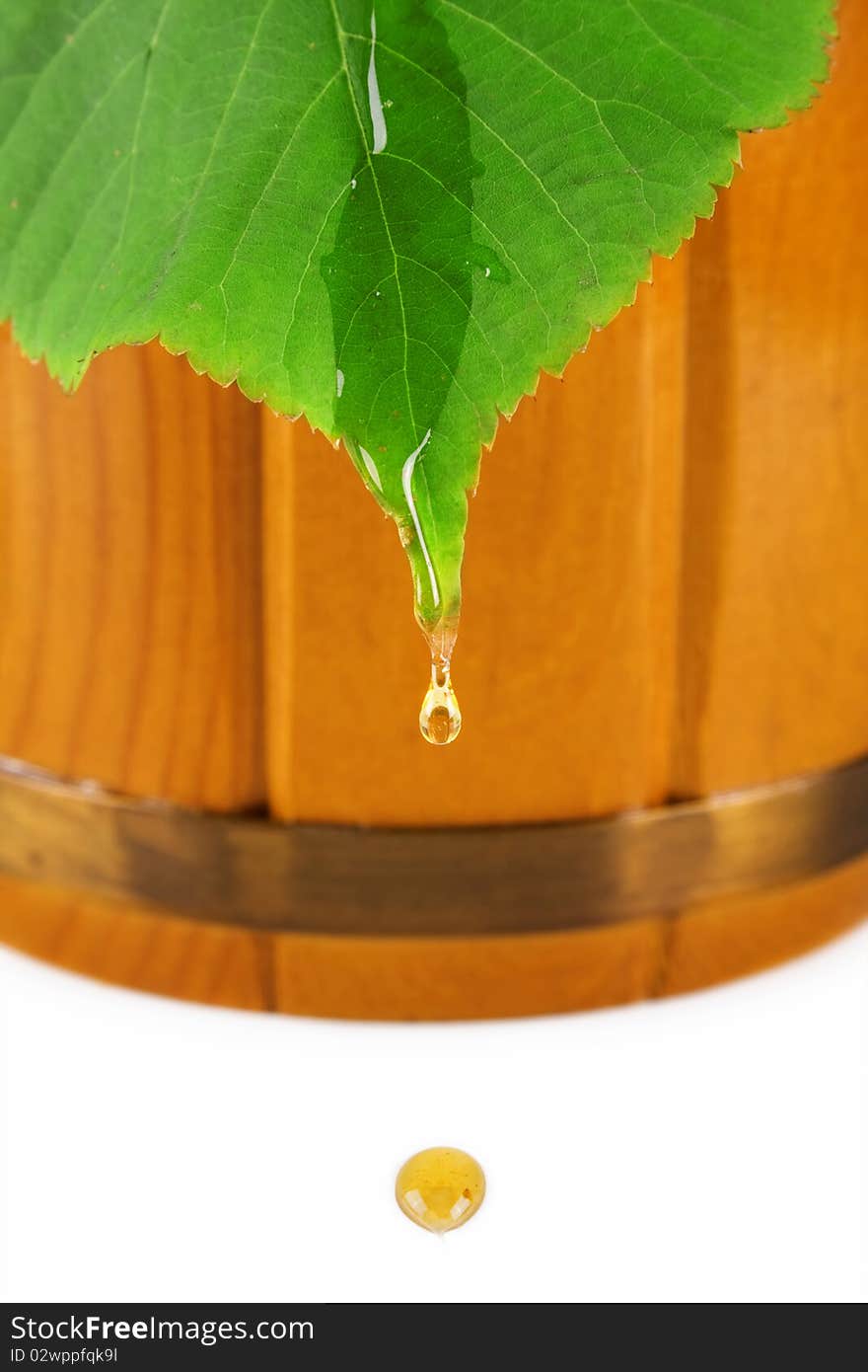 Wooden barrel, drop of honey and leaf linden