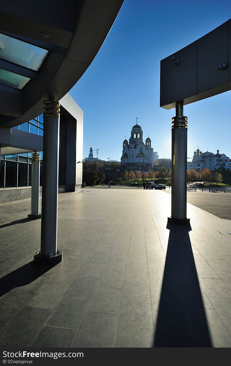 Modern building with shadows and an old orthodox temple in the background. Modern building with shadows and an old orthodox temple in the background