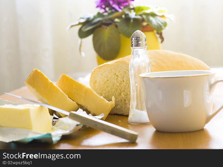 Two pieces of bread, butter and a cup of milk for breakfast. Two pieces of bread, butter and a cup of milk for breakfast