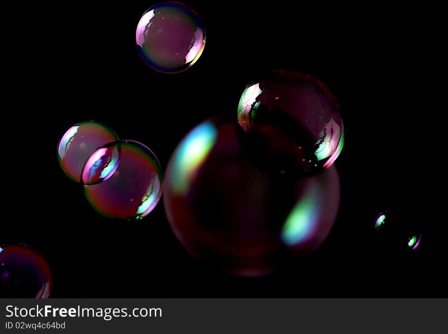 Seven soap bubbles isolated on black