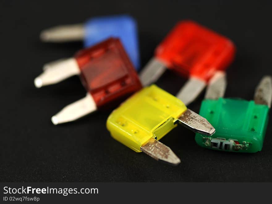 Electrical automobile fuses with shallow depth of field on black background