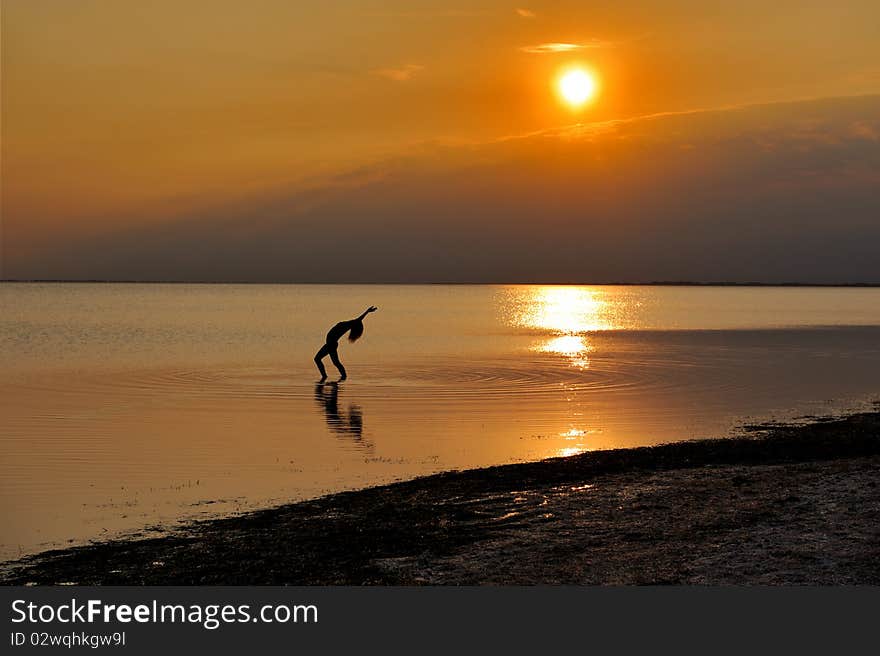 Landscape of evening sea with the silhouette of girl.