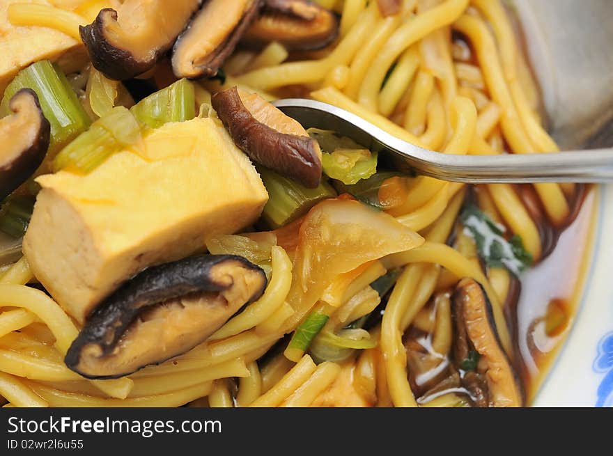 Eating Oriental style soup noodles with fork. Eating Oriental style soup noodles with fork.