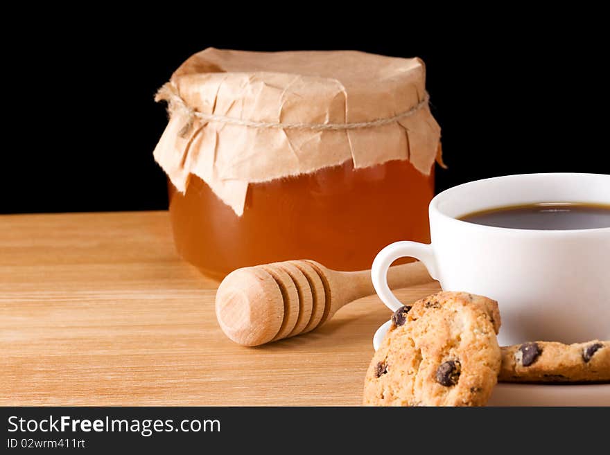 Coffee, honey and cookies on table