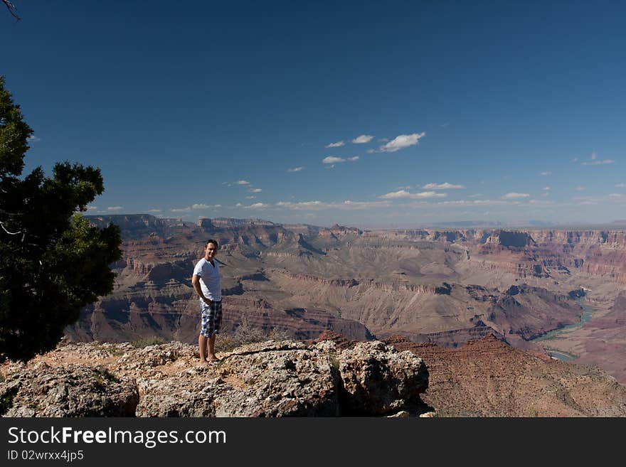 A man posing on top of a mountain at the canyons in USA. A man posing on top of a mountain at the canyons in USA