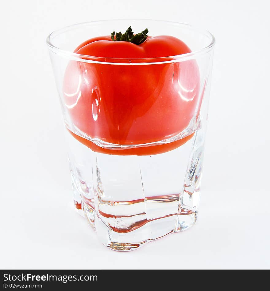 Tomato in a glass of water isolated