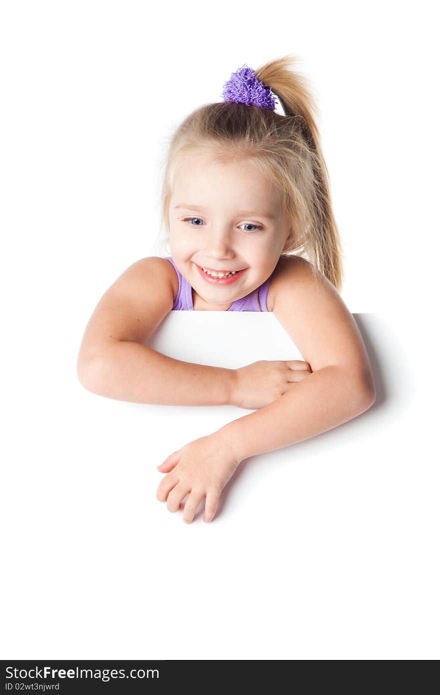 Smiling little girl looking over empty board isolated