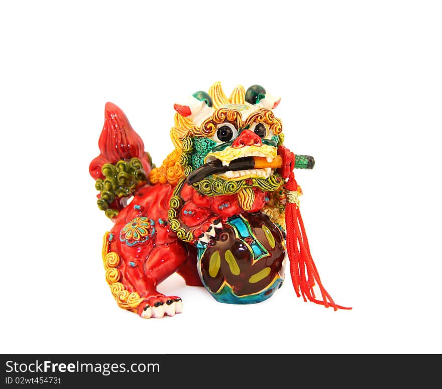 Multi-colored mystical Asian lion with a dagger in a mouth and a sphere in paws. Multi-colored mystical Asian lion with a dagger in a mouth and a sphere in paws