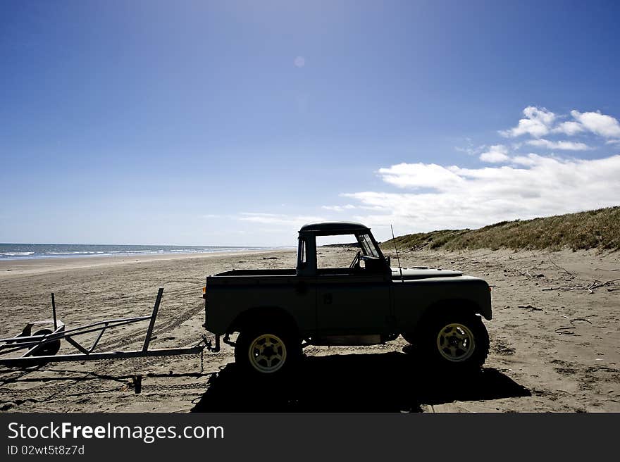 Silhouette of a four wheel drive on a deserted West Coast New Zealand beach. Silhouette of a four wheel drive on a deserted West Coast New Zealand beach