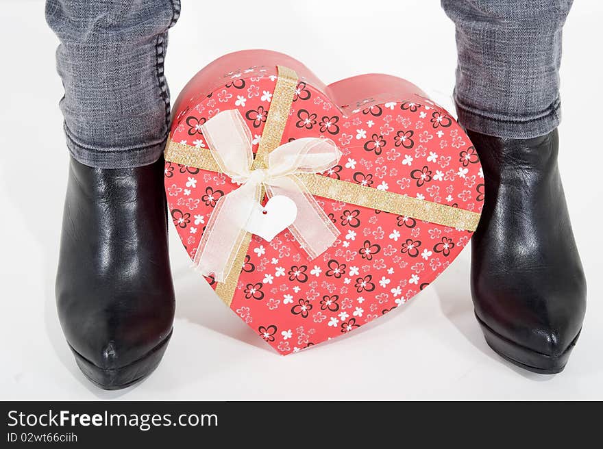 Woman holding a heart shaped box between her feet. Woman holding a heart shaped box between her feet