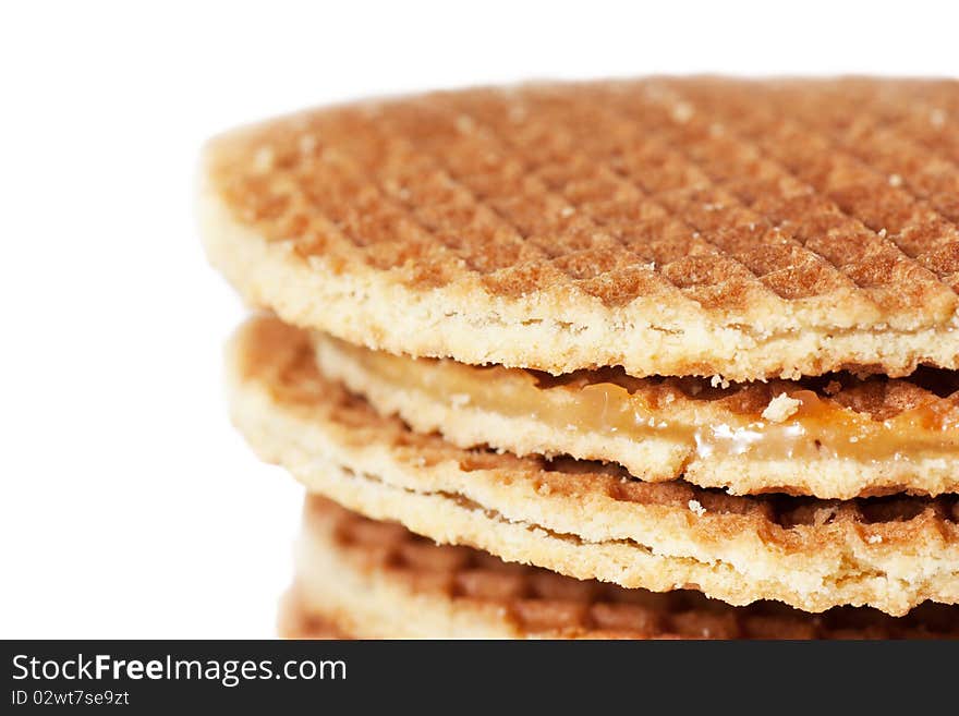 A stack of golden round waffles with caramel isolated over white background.