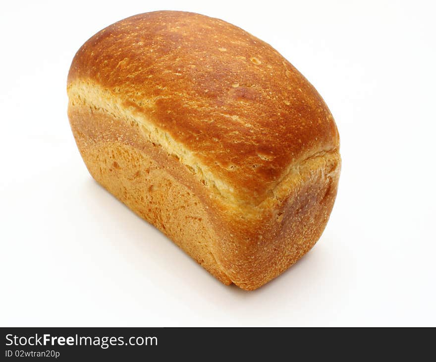 The ruddy long loaf of bread with the fried crust is isolated on a white background