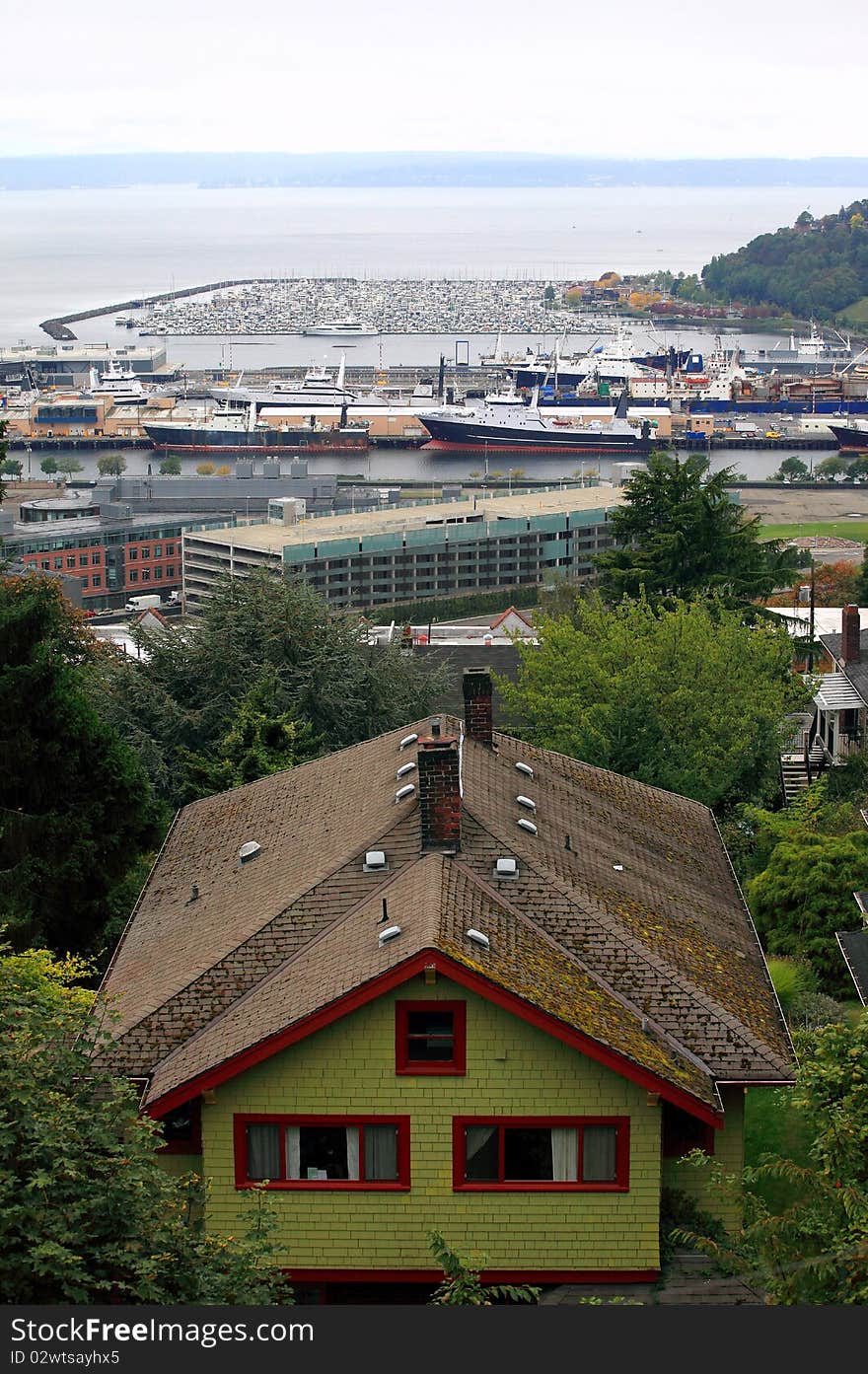 A house on a hillside with the distant marina and fishing vessels in Seattle harbor. A house on a hillside with the distant marina and fishing vessels in Seattle harbor.