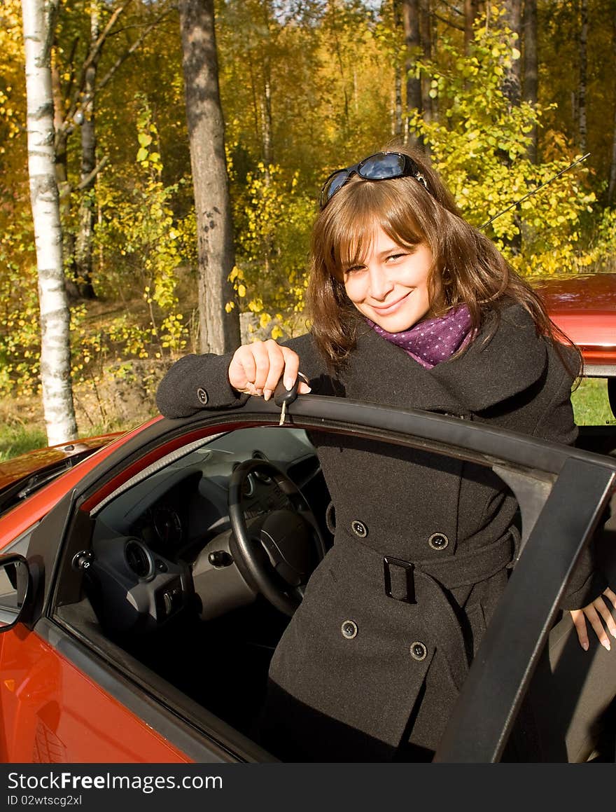 The girl with a key leaves the red car