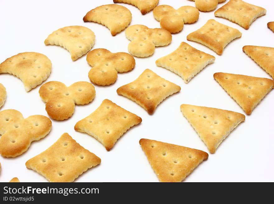 Salty crackers of the various geometrical form lie on a white background. Salty crackers of the various geometrical form lie on a white background