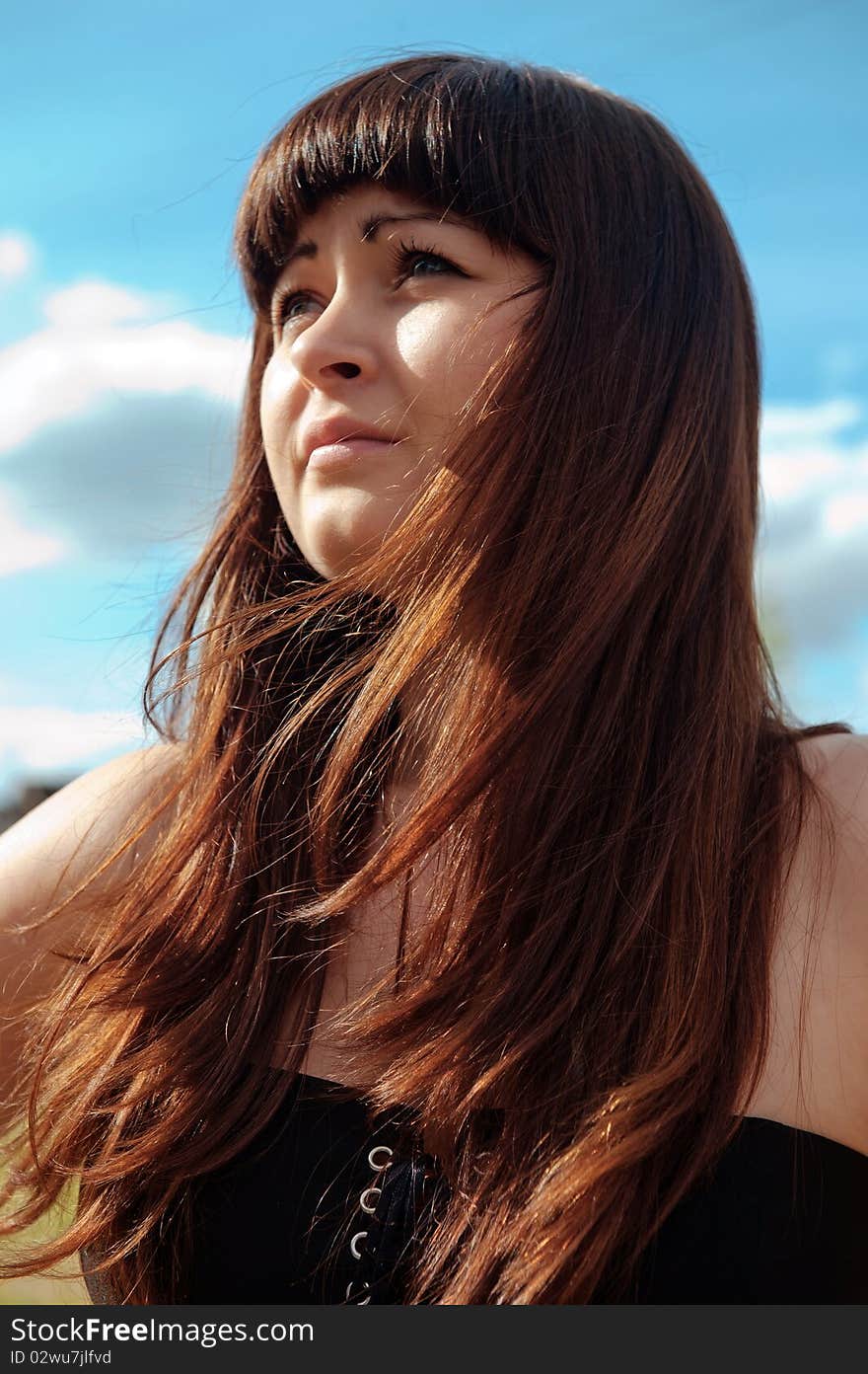 Portrait of young, beautiful red-haired woman with blue sky on the background. Portrait of young, beautiful red-haired woman with blue sky on the background.