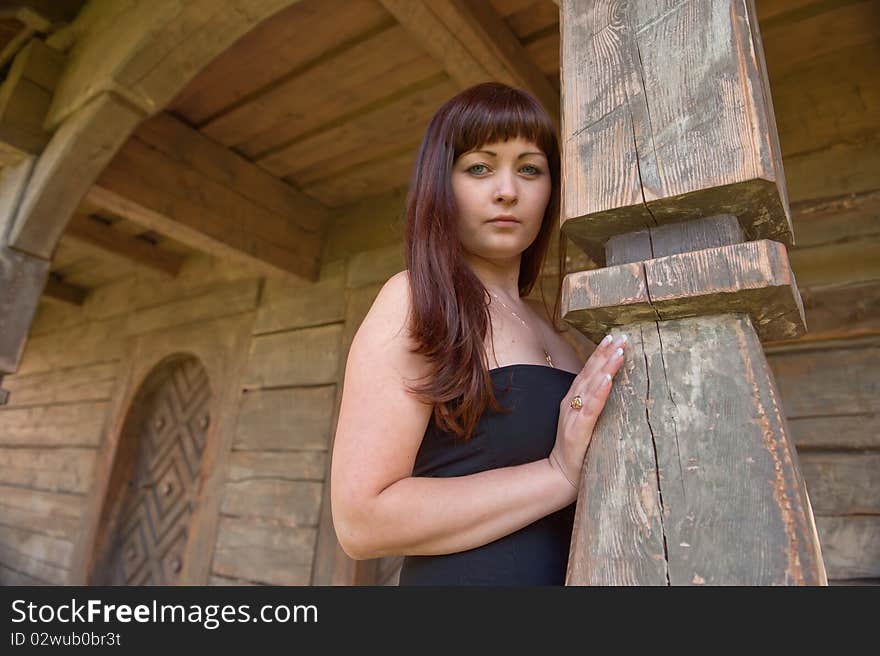 Young beautiful woman leans on arch of homestead. Young beautiful woman leans on arch of homestead.