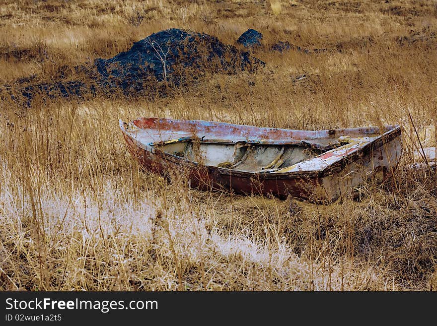 The thrown boat costs in a yellow grass