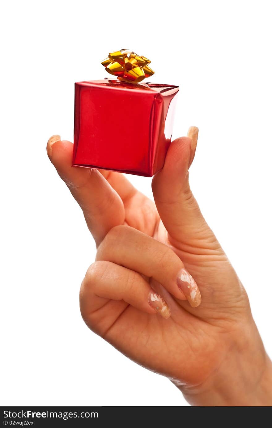 Woman's hand with a small red gift box with gold bow isolated on white background