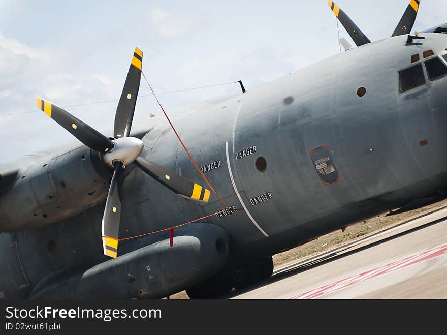 A military transport airplane parked on the apron of the runway