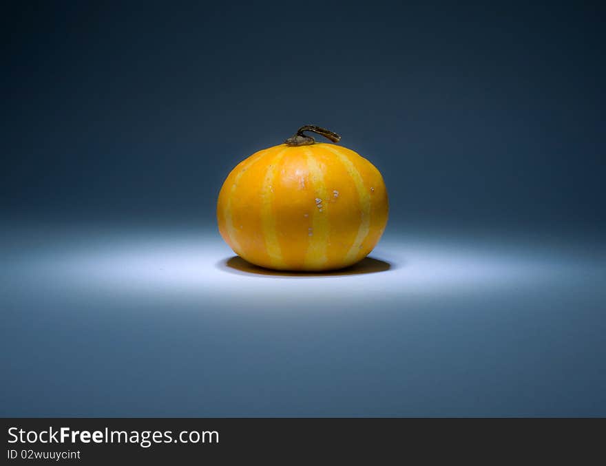 White and yellow striped pumpkin in the dark