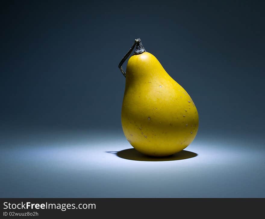 Yellow pumpkin like pear in the dark