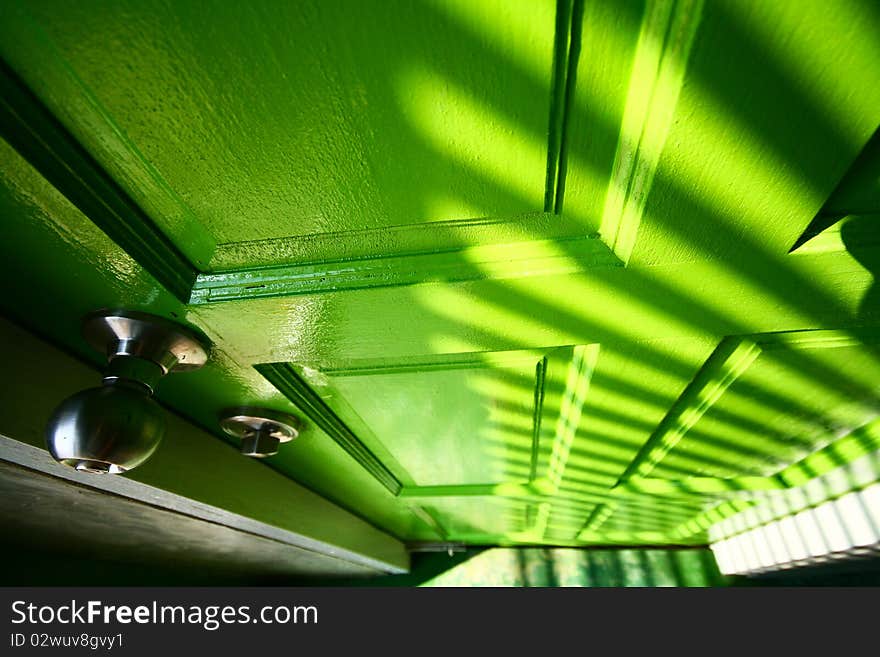 The graphic of highlight and shadow on green door.