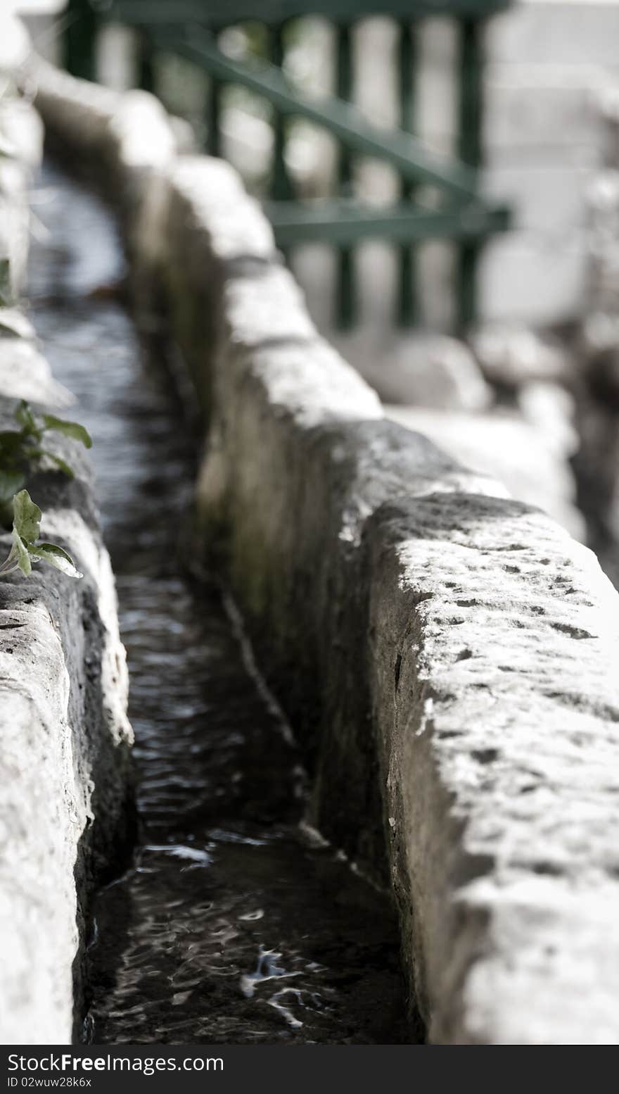 A stone water trough with freash water from a natural source flowing through.